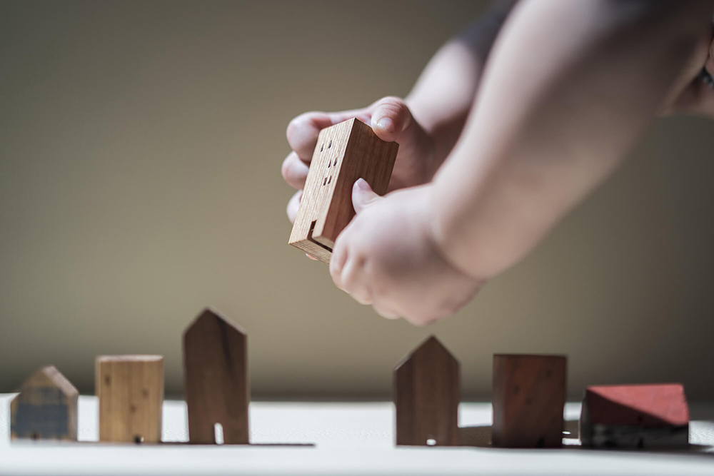 Baby Hands holding a house model